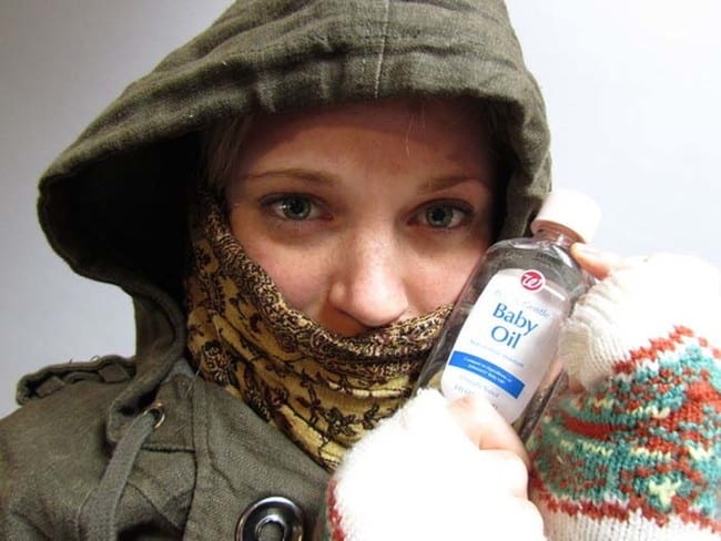 Person holding a bottle of baby oil in cold weather