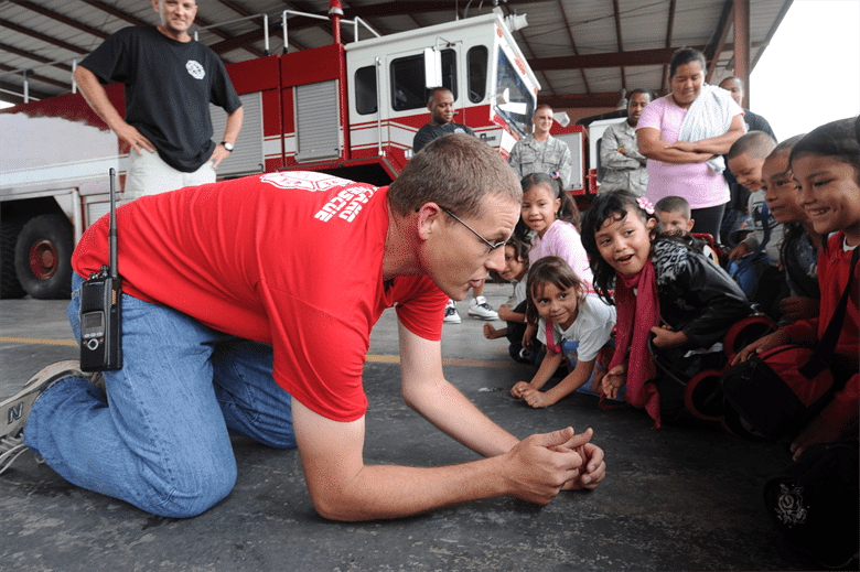 Emergency responder demonstrating a safety skill to children
