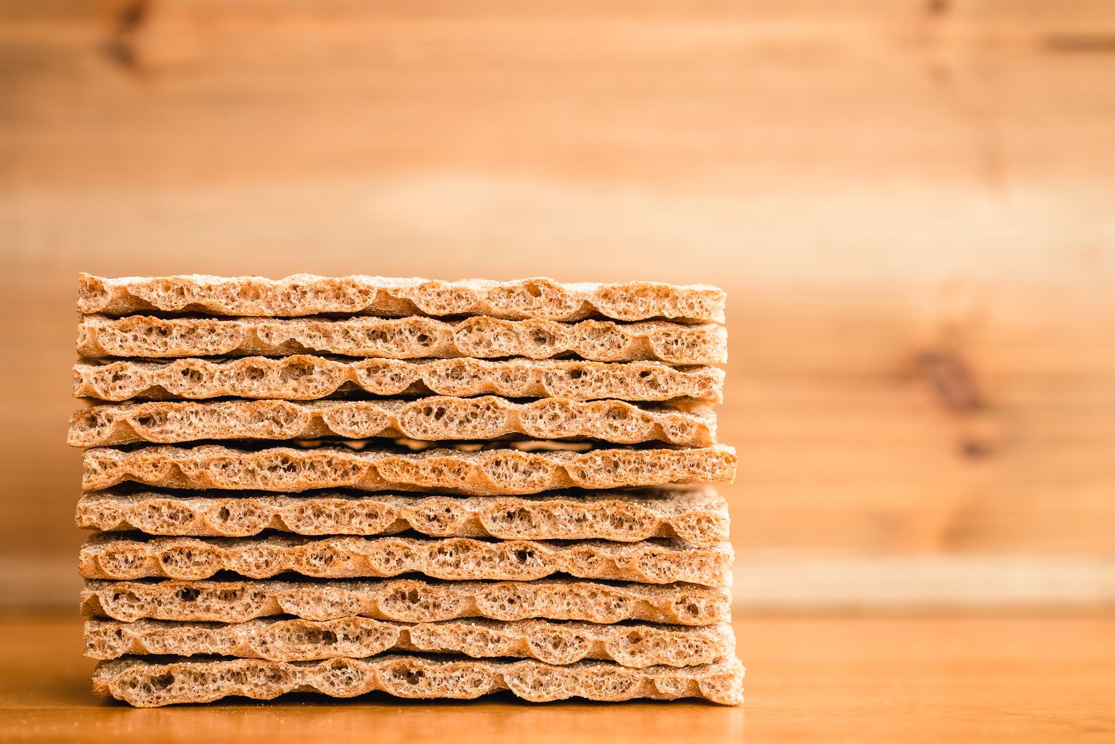 Stack of dry crispbread crackers on a wooden surface