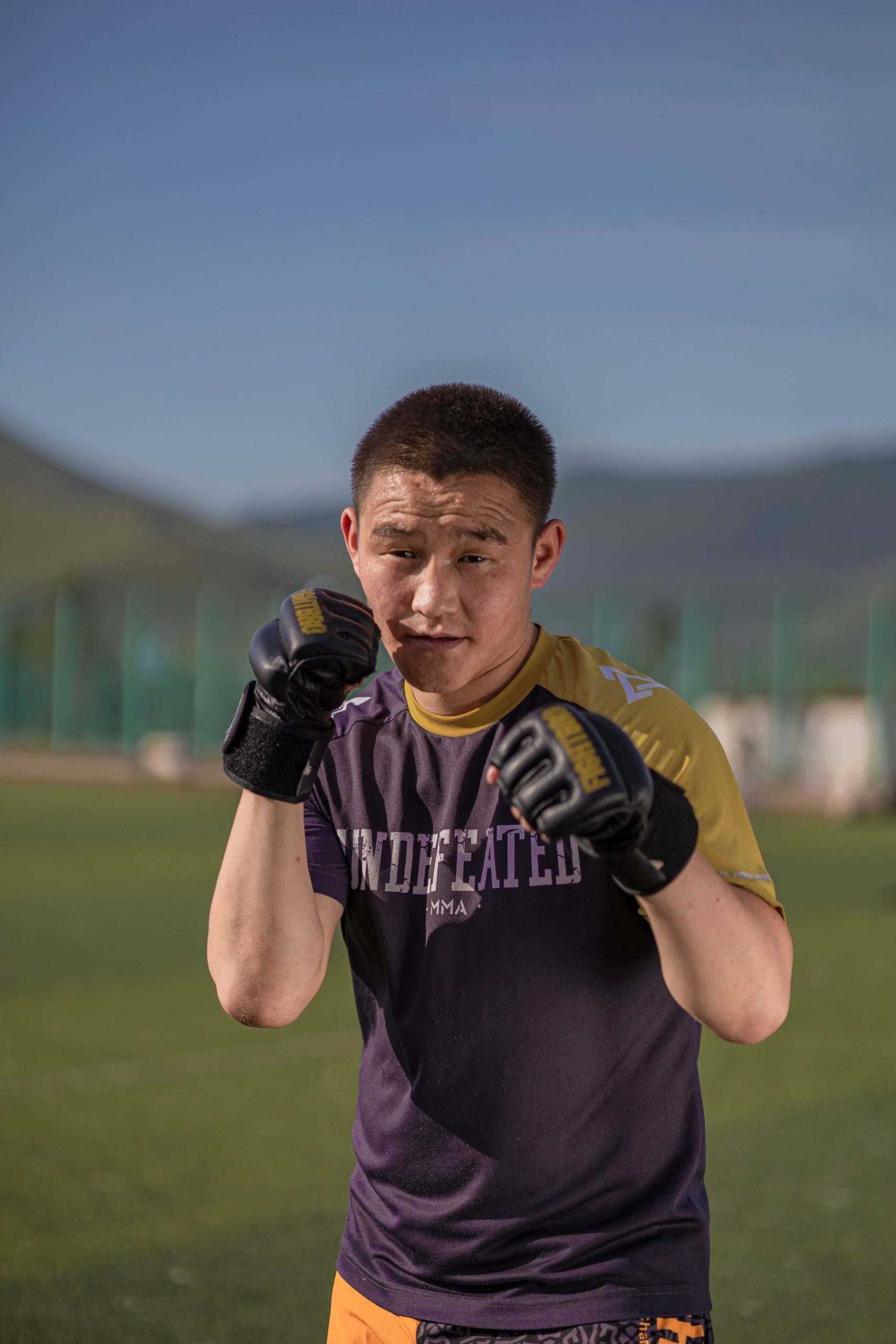 Man practising boxing outdoors in a mountain landscape