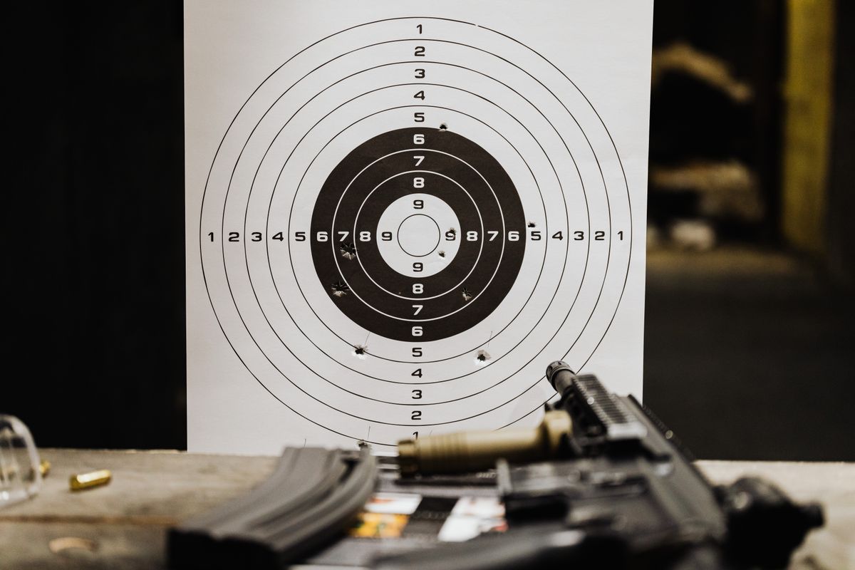 Paper shooting target beside a rifle at a supervised indoor range