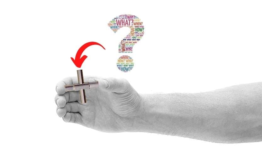 Hand holding a four-way sillcock key with a turning arrow