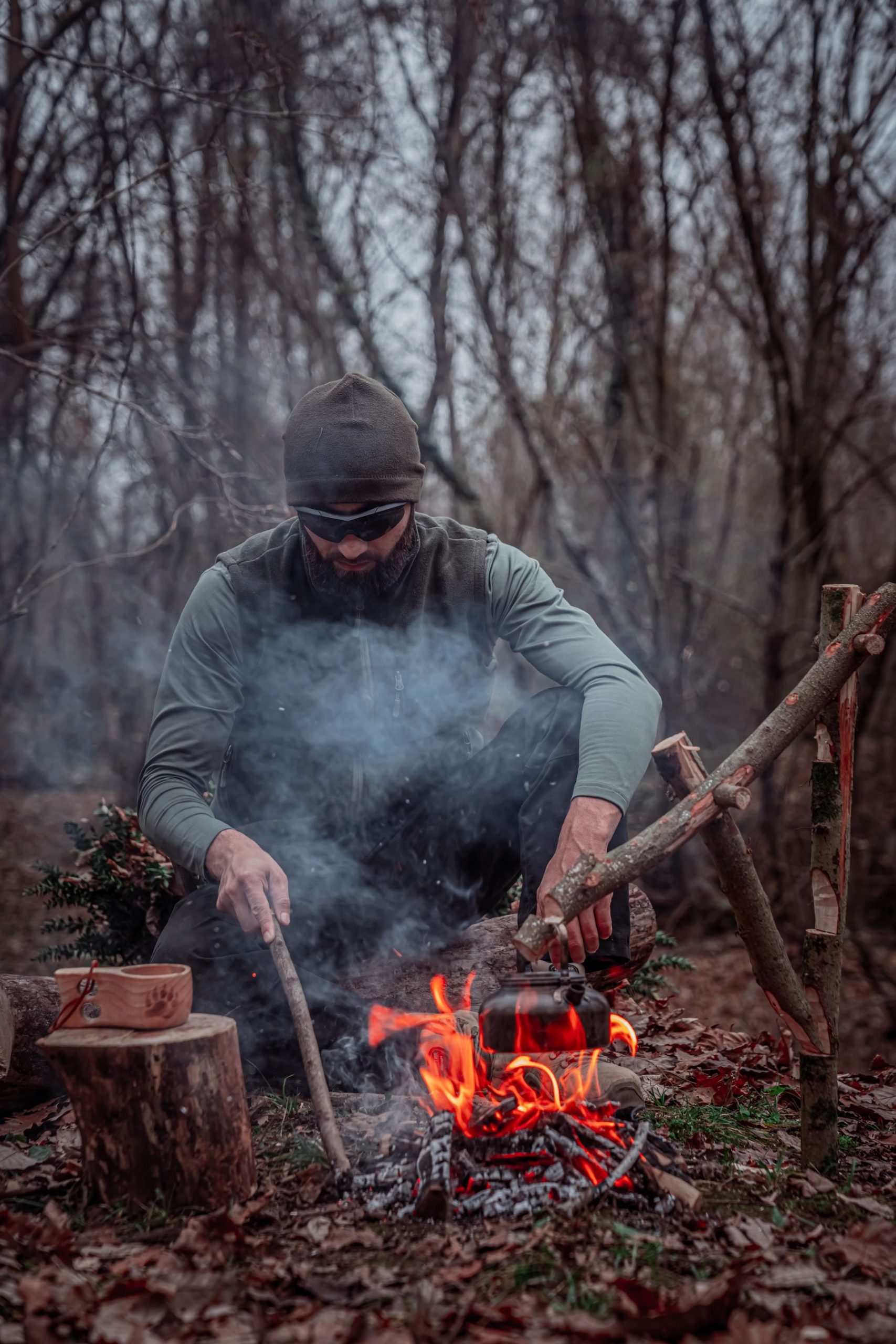 Survival practitioner building a campfire in a forest