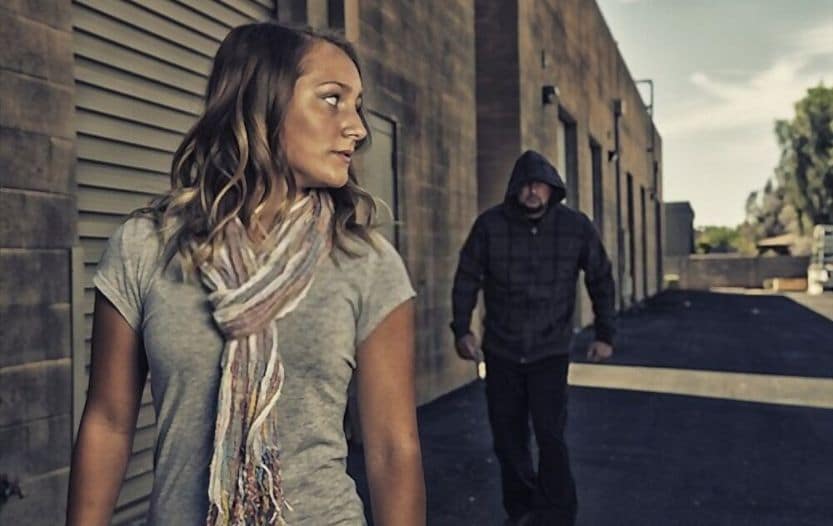 Woman noticing a person following at a distance